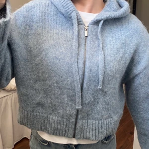 Stickad kofta  - En kortare stickad kofta med luva💙är i en ljus blå/grå färg, använd en gång 