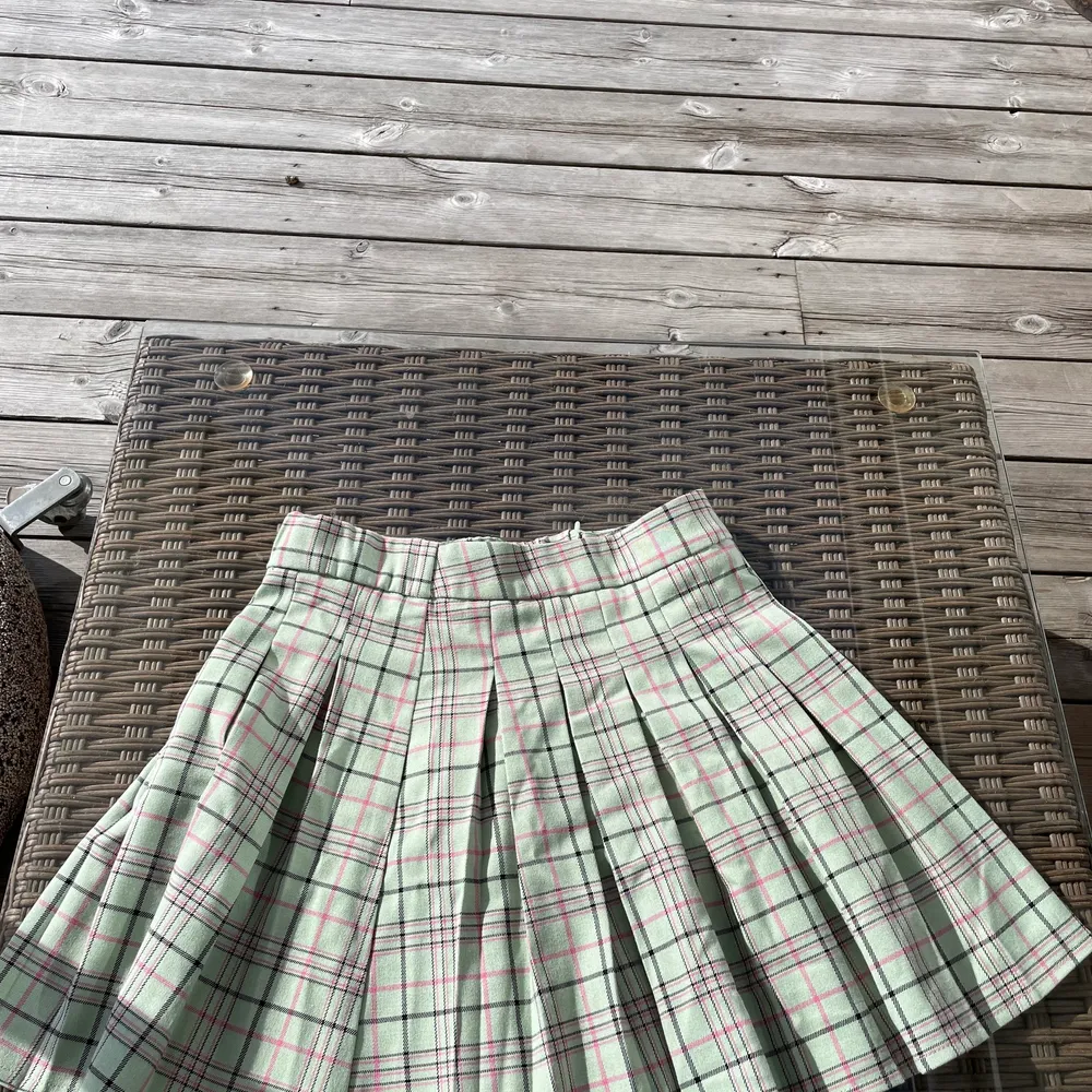 En tennis kjol som e rutig med färgen grön och små detaljer med svart och rosa men det är ett mjukt material  och det är en liten slits med dragkedjor som går ner långt, andvänd 2 gånger och i som nytt skick! Säljer denna för att jag aldrig andvänder denna! Du står för frakt som är 45 k💚🖤💜. Kjolar.