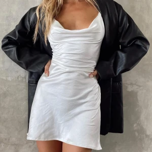 Vit satinkkänning Motel Rocks  - Vit trendig satinklänning från Motel. Strl S, sitter sjukt snyggt då man kan justera midjan (i ryggen). Köpt för 50€. Helt ny, oanvänd. 