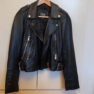 Äkta skinnjacka från Zara - Äkta svart skinnjacka från Zara. Storlek XS men passar en liten S också, använd en gång och är som ny! Kan mötas i Uppsala annars står köparen för frakten! ☺️