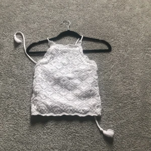 Virkad vit topp - En så SJUKT fin virkad topp från Hollister som jag ÄLSKAR som tyvärr har blivit för liten över min bröstkorg. Denna topp täcker allt och man ska inte behöva ha en BH under, är snörad superfint bak. Kan fixa fler bilder, köparen står för frakten ❤️