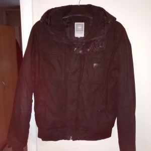 Svart varm jacka stl L med luva. - Fin och välvårdad gammal jacka svart med luva och dragkedja och knapp fram och fickor.obetydligt slitage finnes .hämtas i Skene alt skickas o köpare betalar frakten o Swishbetalning tillämpas alt kontant betalning.