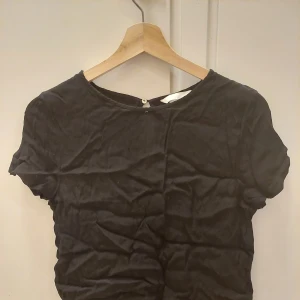 Blus, 36 - En svart blus i bra skick med en lite knapp på baksidan. Säljes för att den inte kommer till användning. Den har då blivit skrinklig.  69kr+frakt