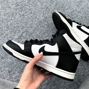 Nike Dunk High Panda - Säljer mina Nike Dunks High Panda i storlek 40 då de knappt kom till användning. Köpte för ett tag sedan på Merchsweden så det är äkta, och orginalbox finns tyvärr inte kvar. Om ni vill ha fler bilder är det bara att fråga:)