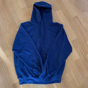 Mörkblå hoodie från fruit of the loom - Riktigt snygg och tålig hoodie från fruit of the loom. Den har en rätt cropped passform, den är ganska kort och bred, riktigt snyggt. STORLEK M