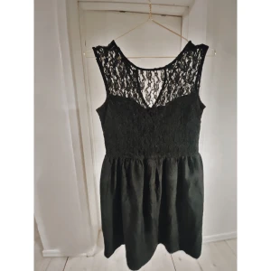 Svart klänning med spets upptill - Svart sommarklänning med spets upptill och knapp bak. Storlek 36. Köpt på H&M, använd flera gånger men fortfarande jättefin. 