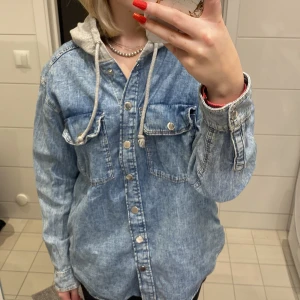 Jeans jacka - En väldigt skön jeans jacka med en hoodie luva som är väldigt mysig. Har 2 bröstfickor och 2 sidofickor. Väldigt skön att ha på sommaren. 