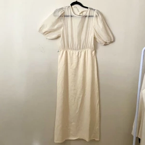 Klänning från Zara - En krämvit klänning från Zara med öppen rygg. Genomskinligt tyg i överkroppen. 