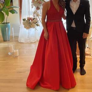 En röd klänning använd endast en gång i storlek M och den har fickor. Säljer för 1800kr och köpt för 4500 