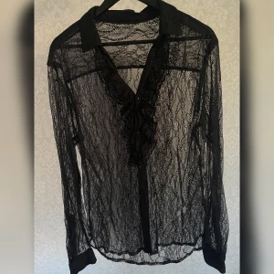 Skjorta seethrough spets - En vintage svart skjorta i spets med ryschdetalj fram. Skulle säga strlk L man, lång och oversize på mig som är 34/36.