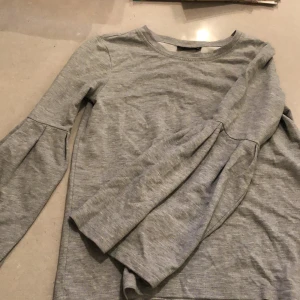 Tröja Xs - Grå långärmad tröja med ”volang” armar. Storlek XS