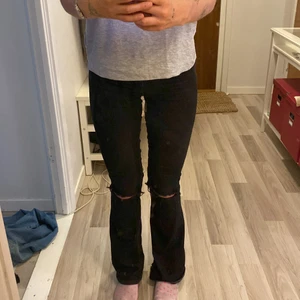 bootcut jeans svarta me hål i knäna  - från gina i storlek xs , egenklippta hål i knäna , typ midwaist/lite högre än lågmidjade ? 