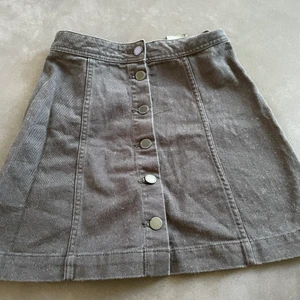 Jeanskjol - Snygg svart jeanskjol, lätt utställd med knappar.