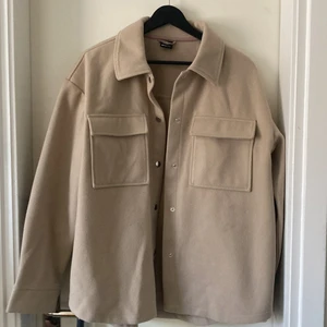 Beige vårjacka - Beige jacka från Gina tricot perfekt till våren och sommaren! Jackan heter Majken jacket och är i färgen Oxford tan, köptes förra våren och säljer då den endast kommit till användning ett fåtal gånger.    Priset kan diskuteras!    Bud på 300 kr!
