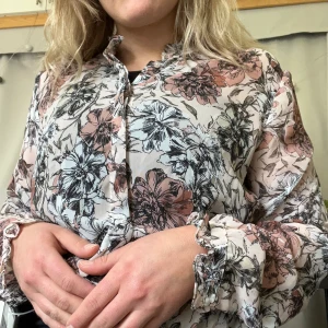 Blommig tunn skjorta - Finare blus i tunt tyg från Soya Concept. Sparsamt använd och har fina detaljer i ärmarna och kragen. Perfekt till höstens möten!  OBS! Frakten är cirkapris.