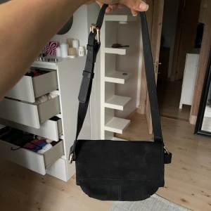 Väska i läder - Svart multifunktionell väska. Man kan ha den crossbody, på axeln eller som beltbag. I äkta läder/mocka. I princip oanvänd. Köpt på Mango för 399kr. 