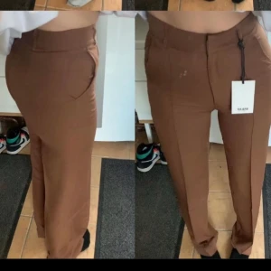 Madlady byxor  - Bruna snygga kostymbyxor från madlady helt oandvända prislappen finns kvar, storlek 34-32