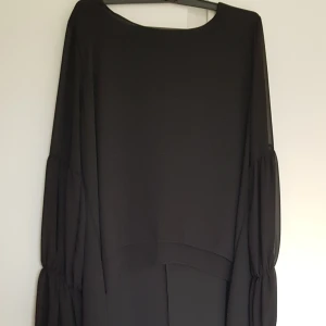Stajl - En jättefin tunika med kortare längd på framdelen och längre på baksidan, fina detaljer på ärmarna som är skapligt genomskinliga, använt ett par gånger, nyskick, passar lika bra till vardag som på fest