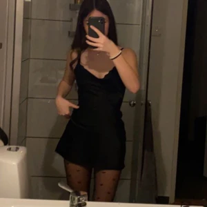 Svart mini klänning - Så fin svart siden-liknande klänning. Finns snörning i ryggen så man kan spänna åt den i midjan. Har likadan i röd och blå (kolla annons för röd för fler bilder) Köparen står för frakten 😊