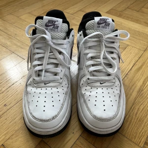 Nike air force 1 - Vita Nike air force 1 med lila detaljer. Begagnade, gott skick på utsida. Slitna insida hälar.