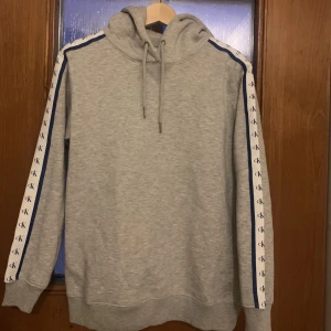 Calvin Klein hoodie - Säljer en jättefin grå Calvin Klein hoodie som knappt är använd i storlek S.