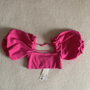 ZARA CERISE ROSA TOPP MED BOLLÄRM OCH SPÄNNEN - Tar emot att sälja denna skönhet från ZARA med ballongärmar och spännen, men kommer tyvärr inte till användning hos mig, därför säljer jag den för ord. pris, eller bud vid flera intresserade. Material: Polyester. Utan anmärkning, ny med tags.