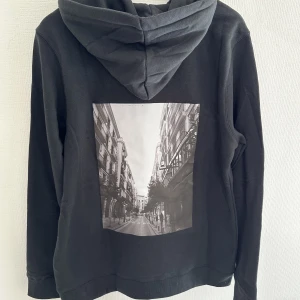 Svart hoodie med tryck på ryggen - Svart hoodie  Storlek: M