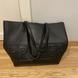 Väska från river island - Köpt från river island, antar att materialet är nån slags fake läder. Väskan är väl använd och ganska sliten mest handtagen, se sista bild. Därav det billiga priset väskan är ganska stor, kan skicka mått om intresse finns.