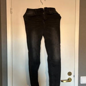 gråa jeans - gråa tighta jeans med lite slitningar längst ner. sparsamt använda.