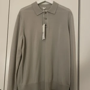 Långärmad pike - En långärmad pike från Arket i färgen beige/grå. Aldrig använd och köpt för 690kr. Köparen står för frakten och priset går att förhandla. 