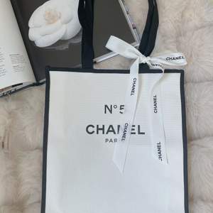 Observera att denna produkt inte säljs i butiker.  Den är en gåva när man köper från Chanels skönhetsbutik. Produkt från en personlig samling. 100% helt ny och äkta. Längd: 35,5 cm  Bredd: ca 30cm Chanel bandet följer med väskan. DM för flera bilder. 
