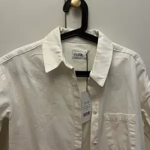 Creme-vit skjortklänning/lång skjorta från NA-KD ( Kim Feenstra), helt oanvänd med prislappen kvar. Stl 34.  