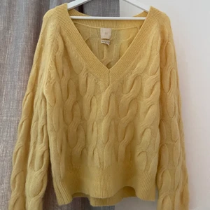 HM stickad tröja storlek XS - En gul oversized stickad tröja från HM med stor V-ringning som är som ny. Skulle säga att den sitter som en M i vanlig storlek. 
