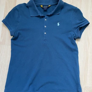 Blå piké från Ralph Lauren i strl 12-14 år - Blå piké från Ralph Lauren i strl 12-14 år. Passar i storlek för mig som är 14 och som vanligtvis har xs. Använd endast några få gånger. Köparen står för frakt:)