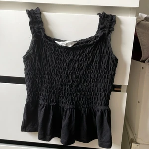 Tröja - Säljer detta svarta linnet med lite volang där nere. Perfekt för sommaren.  Köptes för 1 år sedan men användigt ca 3 gånger. Den är i storlek 140/8-10år men för mig som är 13 år passar den perfekt. Bra skick köparen står för frakten 