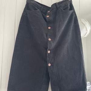 midi jeans skirt in black from Monki. buttons at the front. two front and back pockets.