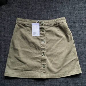 Oanvänd Kjol Monki stl 38 - Oanvänd militärgrön kjol från Monki stl 38  Säljer pga fel storlek Fint mönster på knapparna också :) 