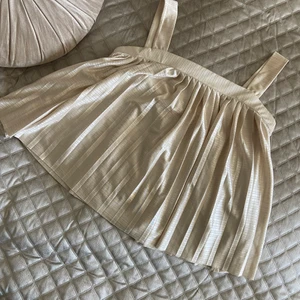 Beige silkeslinne  - Säljer mitt silkeslinne i beige färg. Jättesnygg topp där man även kan bära den utan banden som en bandeautopp. Passar xs-m