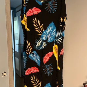 Fin svart exotisk klänning med fjädrar. Storlek XL - Står xxl men som xl. Köpt utomlands. Mycket fin. Svalt material. 
