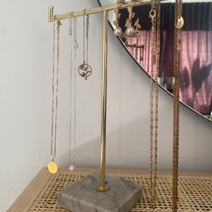 Smyckesträd / Smyckesställ - Smyckesställ från Söstrene Grene. Guld med marmor platta. Gott skick, prislapp kvar. Endast några märken från halsband som hängt men kanske går att putsa bort. Hämtas eller möts upp i Stockholm.