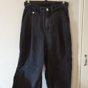 Mörkgråa byxor Monki strl 36 - Mörkgråa byxor från Monki i strl 36. Inte hellånga, utan går ner till vaden ungefär. Hög midja, breda ben. Fint skick och supersköna på! Är gjorda i ett material som liknar tunnare jeanstyg, så de funkar även vår och sommar.