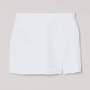 Vit kort kjol med sluta i linnematerial ifrån H&M. Superfin och bekväm. Använd bara fåtal gånger. Jättesnygg att matcha med en linneskjorta. 