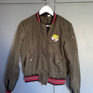 Bomberjacka - Militärgrön bomberjacka med detaljer. Mycket fint skick. 