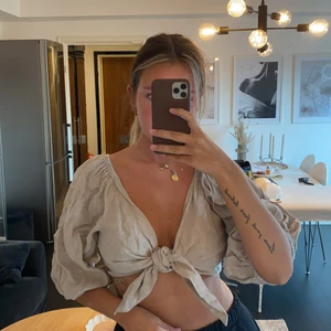 Linne topp - En biege topp i linne som man knyter framtill. Oanvänd med lappar. Från ginatricot, finns ej kvar. Storlek 36. 