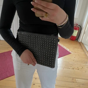 Clutch med nitar - Säljer denna snygga och coola clutchen/väskan, då man sätta på att längre band eller ha utan❤️‍🔥 knappt använd och så snygg! Har som nitar på framsidan, och super rymlig🤩 köparen står för frakt
