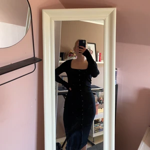 Svart Långklänning  - Svart långklänning från NA-KD, ribbad och med knappar  (som inte går att knäppa upp) hela vägen ner, fyrkantig ur ringning. Använd Max 1 gång, i storlek S, men passar M också då den är så töjbar. Jättebekväm och sitter jättefint runt kroppen! Säljer då jag inte använt den, Frakt betalar köparen om möte inte funkar 🌼