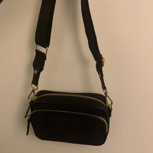 Axelremsväska  - En axelremsväska från H&M. Den har två fack ett lite större med en inne ficka och ett lite mindre fack på  utsidan. Den har stjusterbar rem. Köpt för ca 2 år sen för 249kr och den är använd ca 1 gång använd. Köparen står för frakten. Möts ej upp 