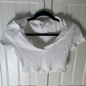 Vit cropad topp - Cropad ribbad t-shirt med v-ringning och krage från Monki.  Köpare står för frakt.  Hör av dig vid intresse!