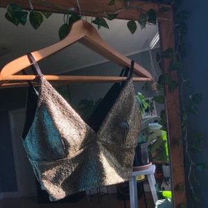 Glittrigt linne - Ett guldglittrande linne med justerbara band från bikbok. Säljer eftersom den inte är min stil. Passar superbra och glittret ramlar inte av!