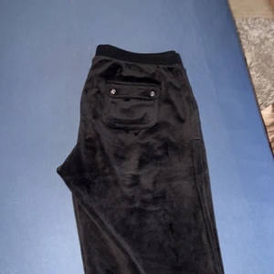 Juicy Couture - Fint skick, använd dom fåtal gånger det finns ett jätte litet hål i en fickan som går att sy ihop.